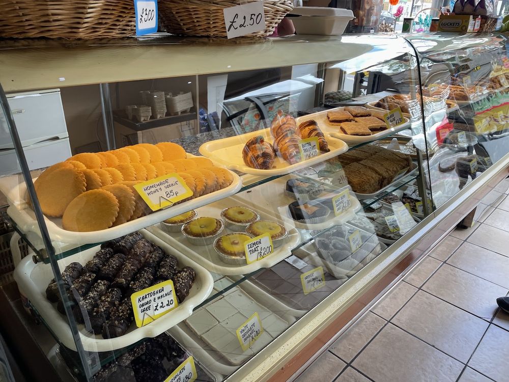 The display counter at Honey Cake packed with trays of cakes, tarts and pastries behind glass